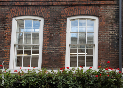 White Windows in Old Brick Wall Over Flower Boxes