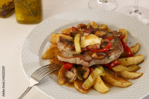 Pork and grilled vegetables arranged on a plate, Traditional dish in elegant setting, Selective focus with soft light