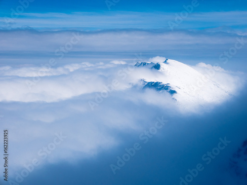 Peaks of tatras mountains above the clouds, Slovakia.
