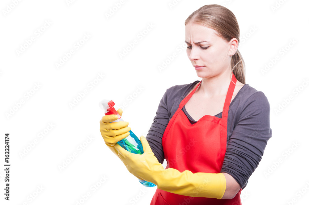 Beautiful woman reading the cleaning spray label Beautiful woman reading the cleaning spray label
