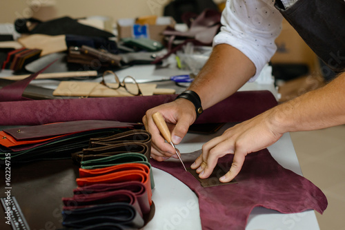 Leather handbag craftsman at work in a workshop © chernikovatv
