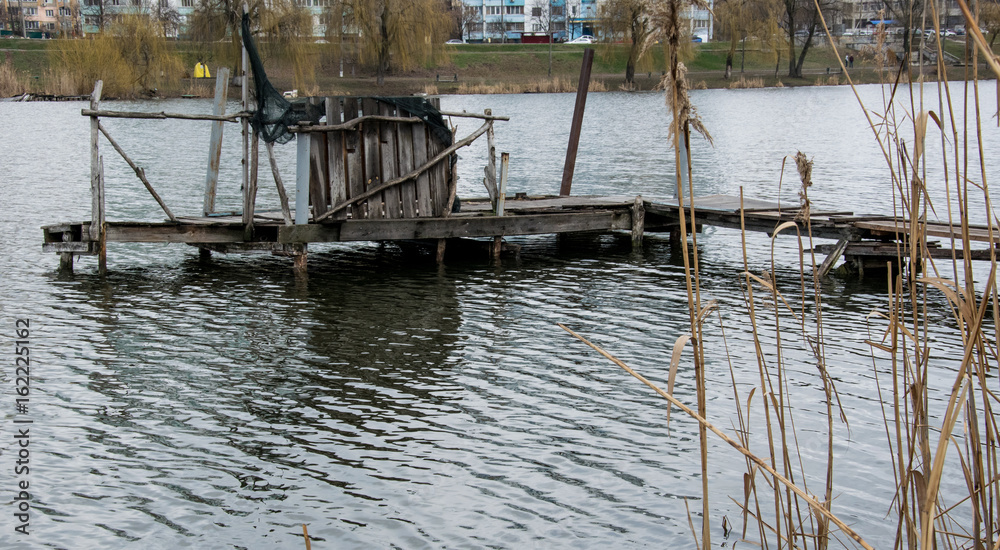 View from the shore to the destroyed bridge on the lake View from the shore to the destroyed bridge on the lake