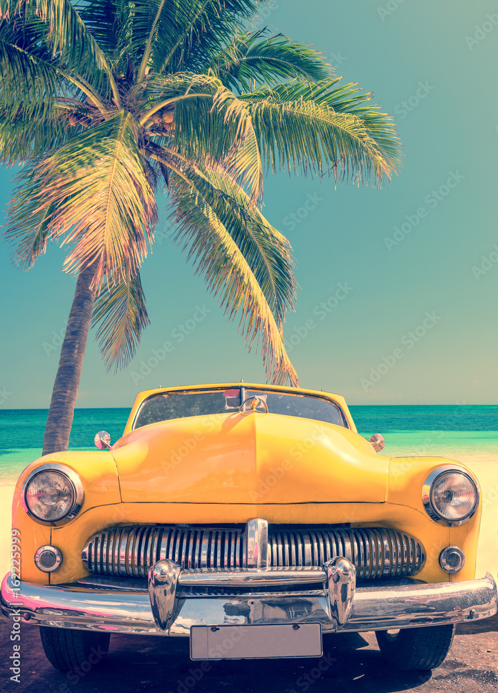 Classic american yellow car on a tropical beach with palm tree, vintage process