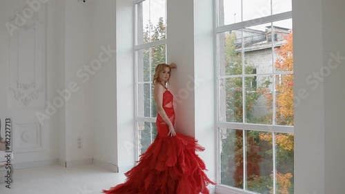 Gergeous woman in red dress posing in studio. Backstage. photo