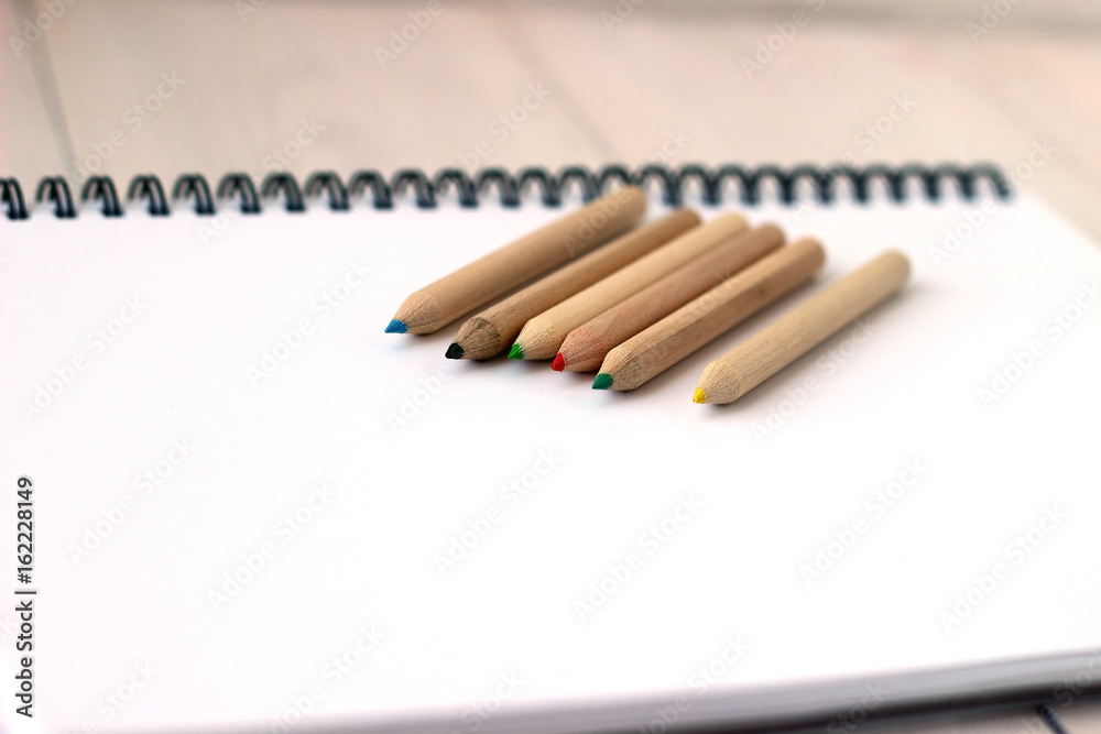 Color pencils on sketchbook, concept of drawing, close up Color pencils on sketchbook, concept of drawing, close up