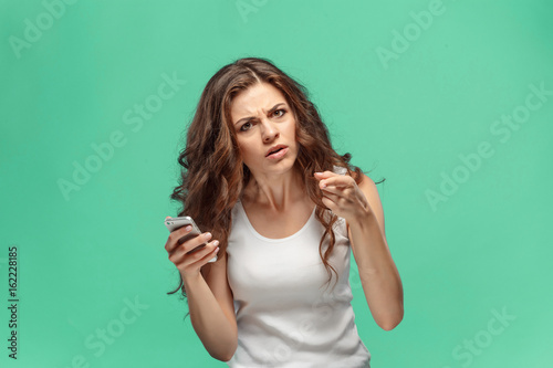 The portrait of disgusted woman with mobile phone