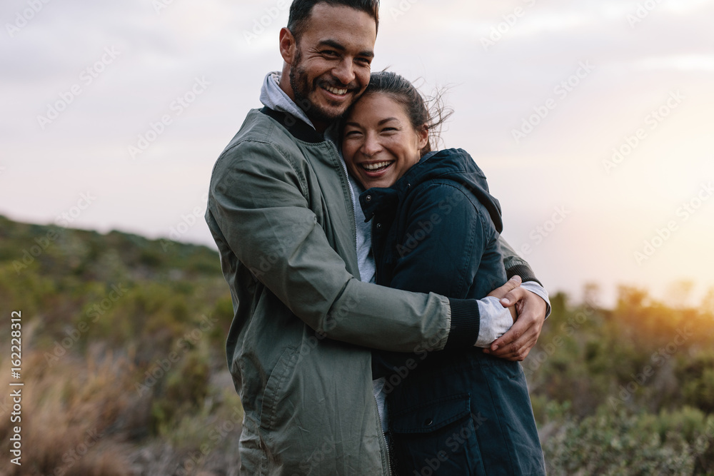 Romantic couple hugging in the countryside