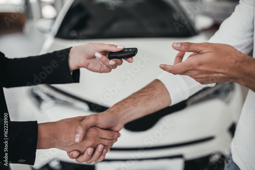 Salesperson with customer in car dealership