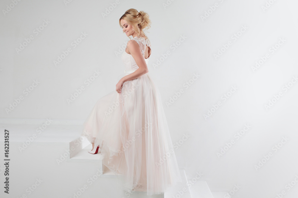 Portrait of a beautiful girl in a wedding dress. Bride, white background, free space on the right