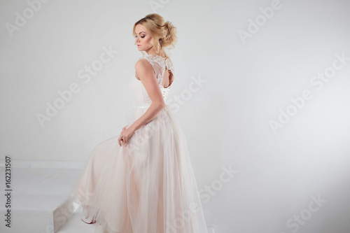 Portrait of a beautiful girl in a wedding dress. Bride, white background, free space on the right