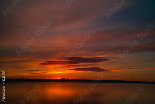 Orange and red sunset at coast of the lake