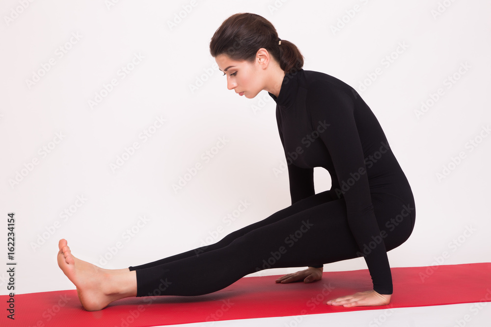 Beautiful athletic girl in black suit doing yoga asanas. Isolated on white background Beautiful athletic girl in black suit doing yoga asanas. Isolated on white background