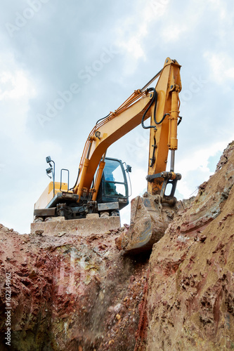 Work of the excavator at the construction site