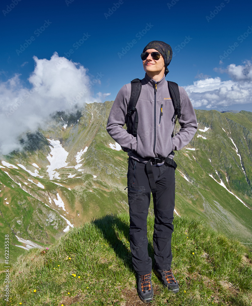 Naklejka premium Young hiker with backpack on a trail