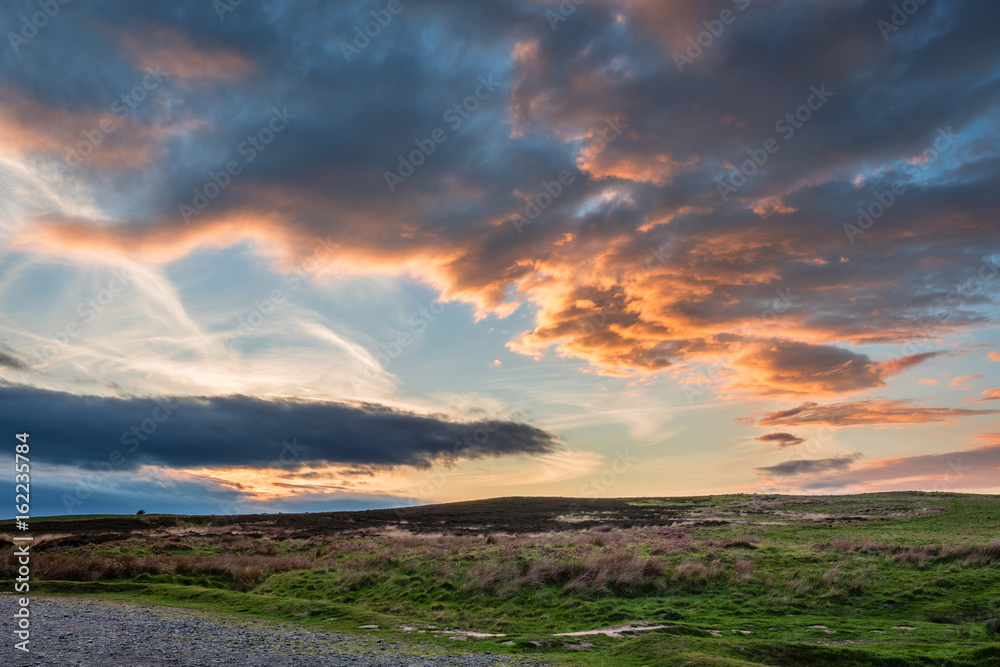 Naklejka premium Sunset over Lordenshaws Hillfort / Lordenshaws Hillfort at the foot of the Simonside hills near Rothbury, in the Northumberland National Park, is popular with walkers