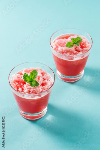 Glass of healthy watermelon juice in summertime on blue background.