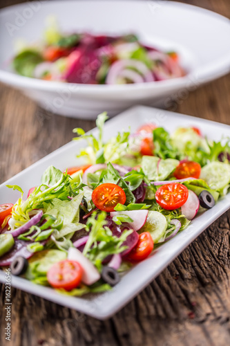 Vegetable salad. Plate of salad with vegetables on rustic oak table. Assortment of ingredients of vegetable salad.