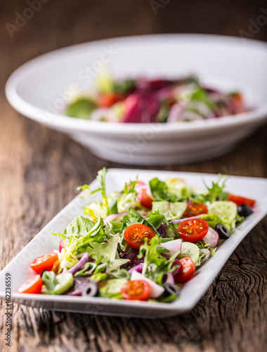 Vegetable salad. Plate of salad with vegetables  on rustic oak table. Assortment of ingredients of vegetable salad.
