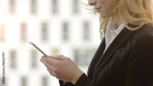 Businesswoman Texting on Smartphone  Businesswoman writing a sms Message in an office.  Shot on a Red Dragon in 4k down convert to HD.