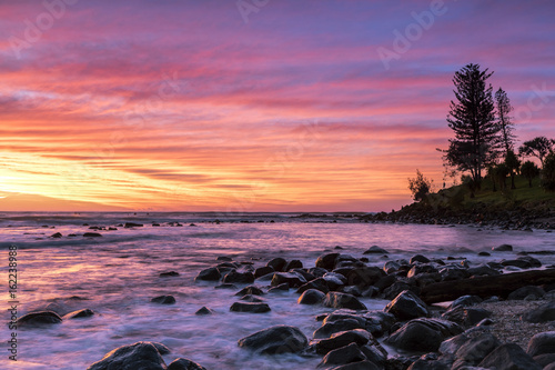 Colourful red and yellow sunrise colours in the clouds at Burleigh Heads Gold Coast.