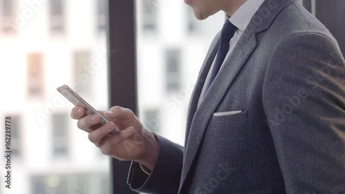 Businesswoman Texting on Smartphone  Businessman writing a sms Message in an office. Shot on a Red Dragon in 4k down convert to HD.