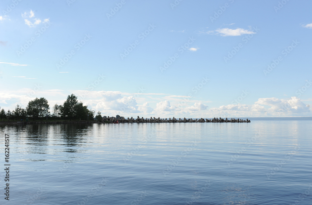 Water landscape on a summer clear day. Blue sky, clouds. Islands far away