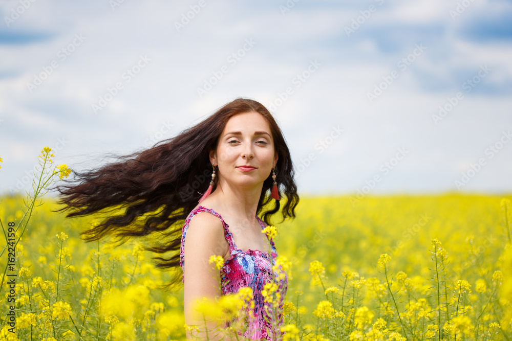 Woman with flying hair on yellow rape field Woman with flying hair on yellow rape field