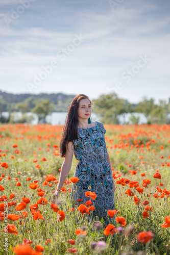 Woman in patterned sundress on sunset flower field