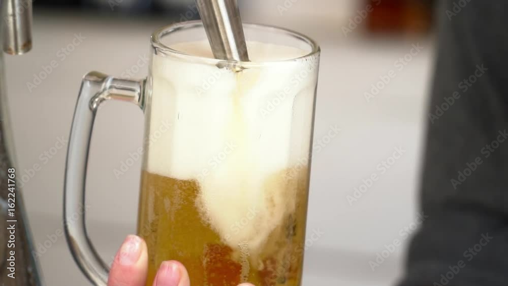Closeup of barman pouring beer with foam into the glass slow motion
