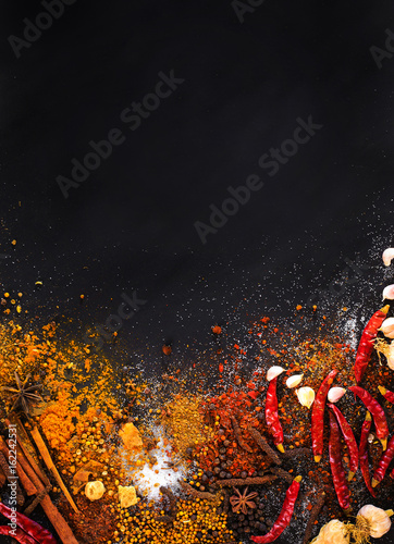 Variety Spices and herbs on black stone background, Top view with empty space background for texture. Italian food, eastern food concept.