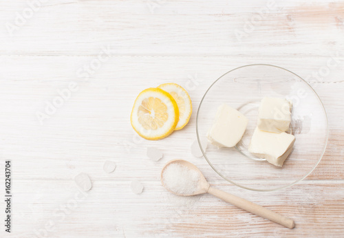 Slices of butter, lemon and sugar on a white table