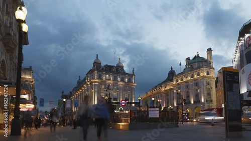 Piccadilly Circus Time-Lapse view with pedestrians, black cabs and red buses. Evening time, with moody blue clouds during the summer.