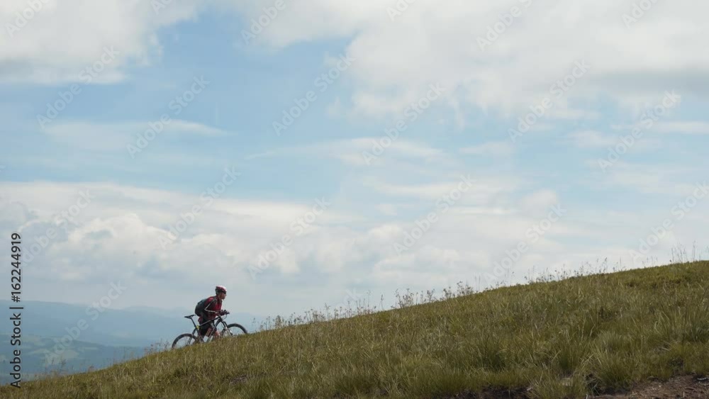 Bicycle biker walks on the top of mountain Bicycle biker walks on the top of mountain