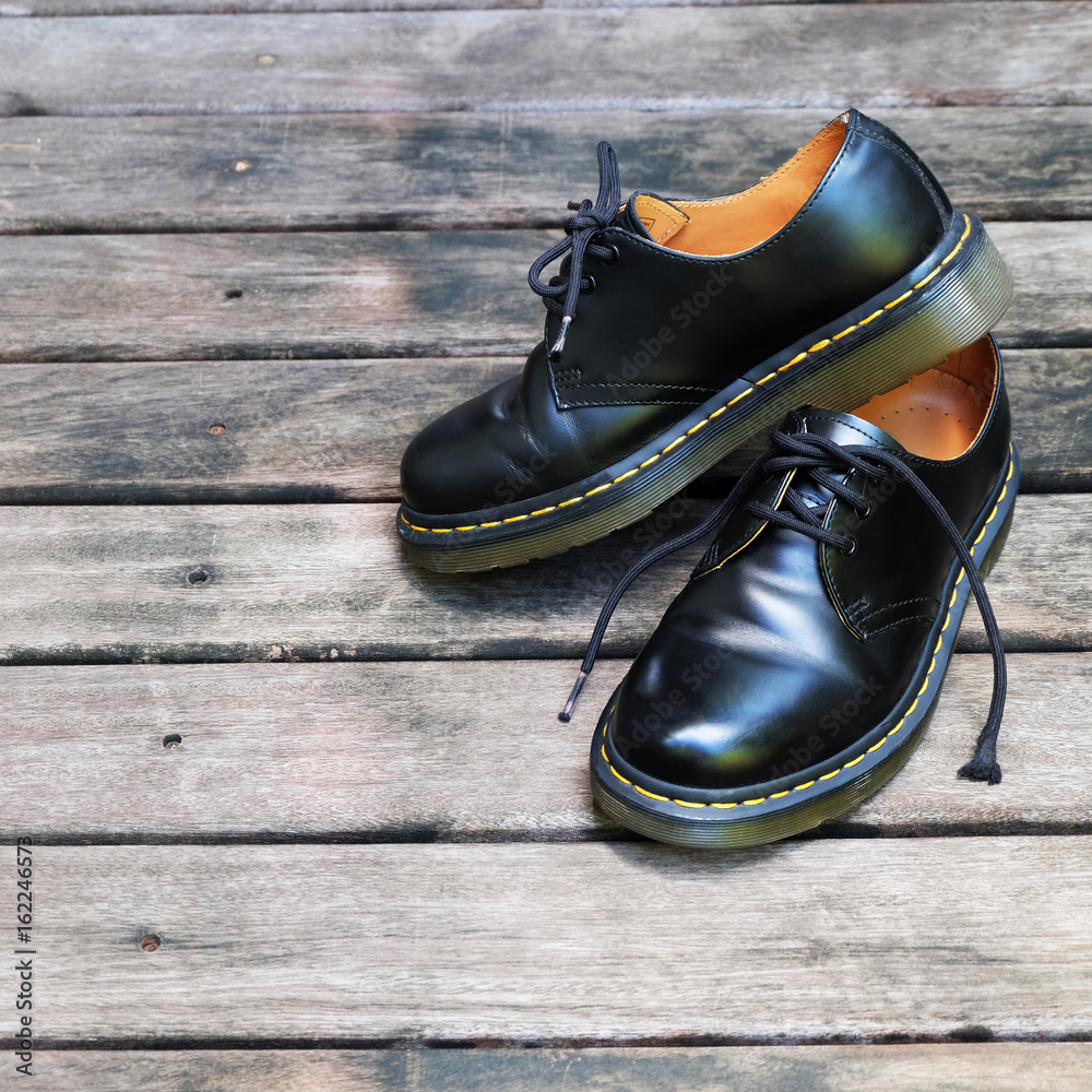 A black leather shoes on rustic wooden background A black leather shoes on rustic wooden background