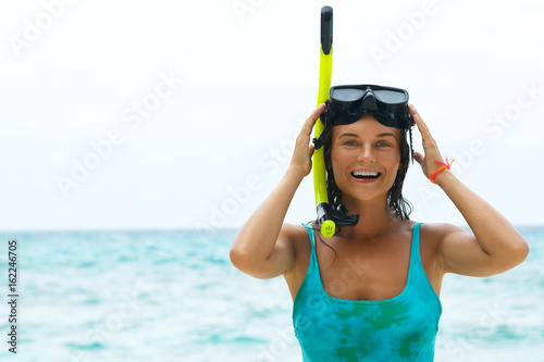 Happy woman on the beach with mask for snorkeling