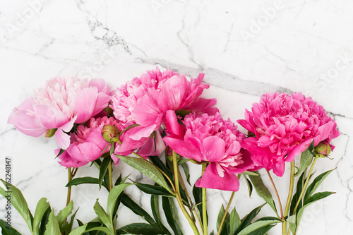 Pink peonies on white marble background