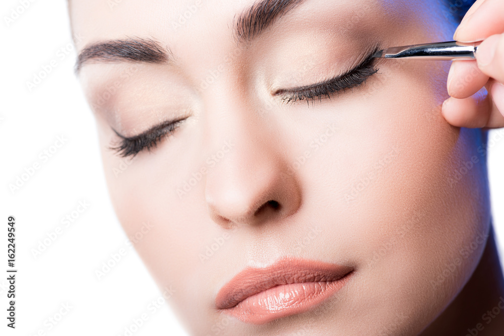 Makeup artist applying eyeliner arrows on face. hand of woman using makeup brush