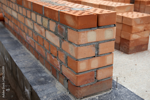 Brick wall. Construction of houses, masonry walls made of red bricks and cement