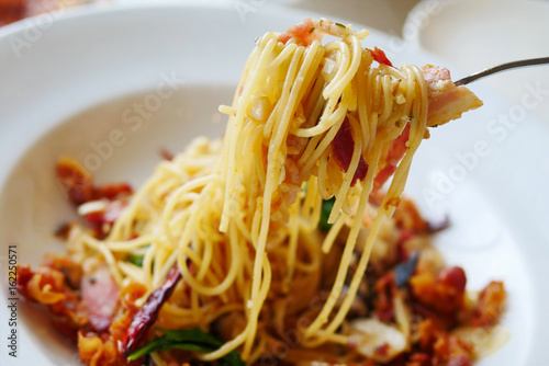 Close up spaghetti with mushroom, bacon, garlic , cheese and dried chilli with fork