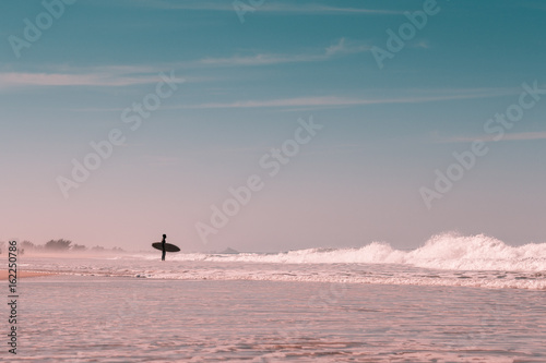 Silhouette surfer in idyllic light beach