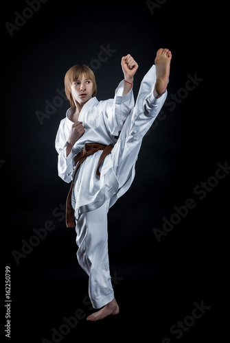Young athlete in a kimono on a dark background