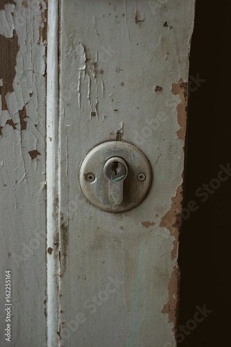 Old wooden rustic grey door texture and keyhole, close up of peeling paint