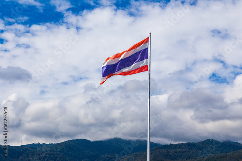 Thai national flag flying on its pole on a bright sunny day