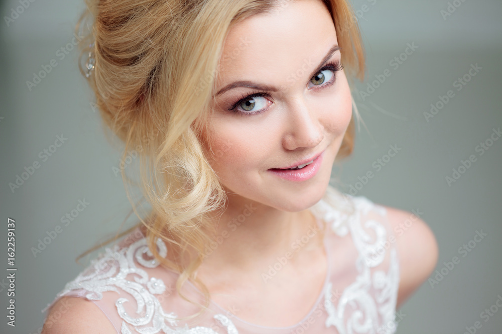 Naklejka premium Portrait of a beautiful girl in a wedding dress. Bride in a luxurious dress on a white background, close-up