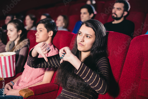 Girl in a movie theater in the session of the film that she does not like
