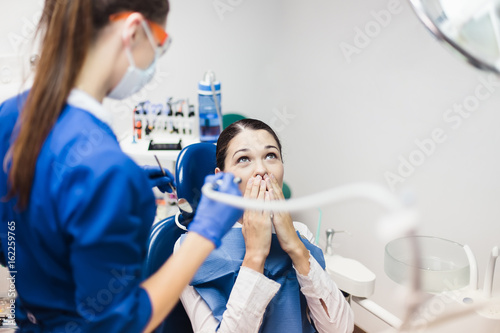 Young woman patient is afraid of dental treatment