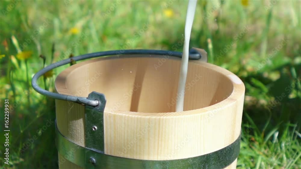 High quality video of milk pouring into wooden bucket in real 1080p slow motion 250fps High quality video of milk pouring into wooden bucket in real 1080p slow motion 250fps
