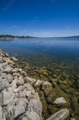 Ferien am schönen Bodensee Sommerzeit mit Steinen am Seeufer und blauen Himmel
