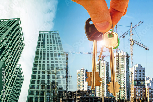The keys on the background of the construction of new modern buildings . The concept of the development of urban construction .