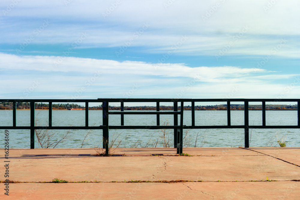 Esplanade with bench in front of a lagoon Esplanade with bench in front of a lagoon